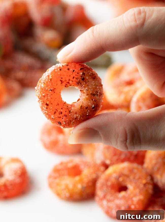 Hand holding a perfectly seasoned Mexican Chamoy Candy (dulces enchilados) ring, ready to be enjoyed.