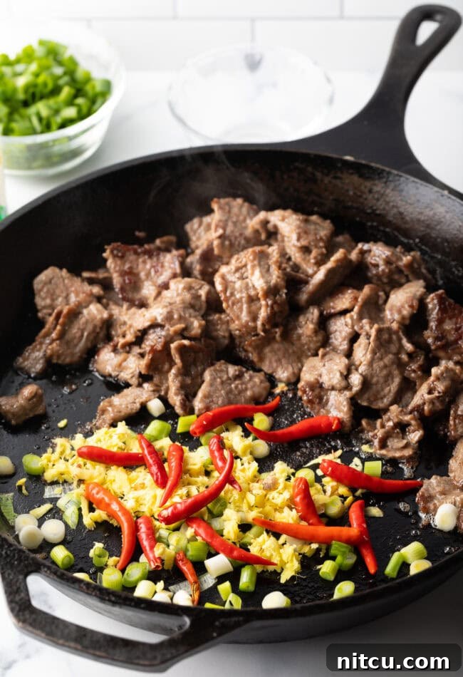 Stir frying various ingredients together in a cast iron skillet.