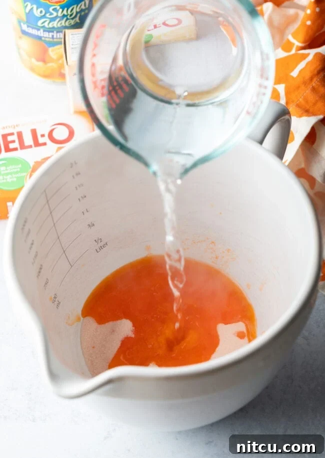 Water being added from a glass measuring cup into a white mixing bowl.