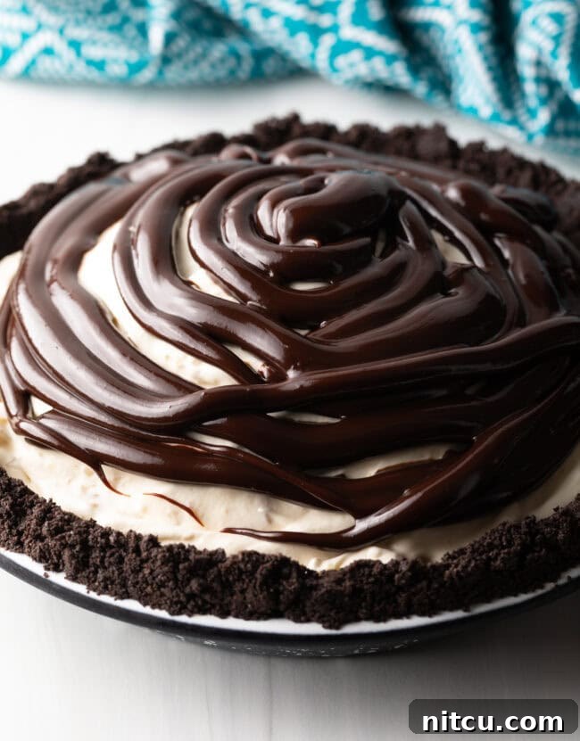Hot fudge being spread over the frozen ice cream pie.