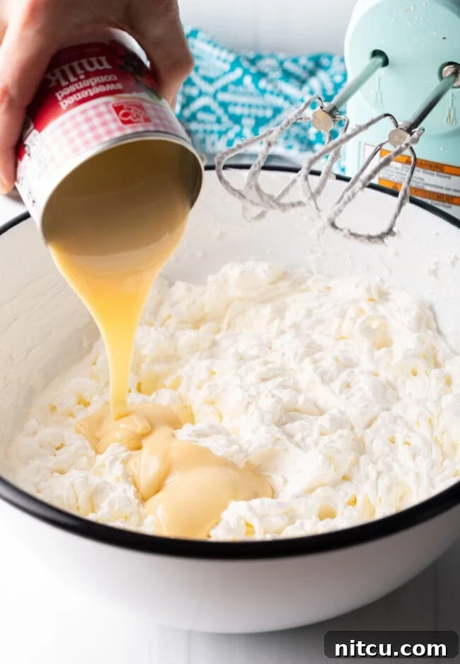 Heavy cream being whipped in a stand mixer.