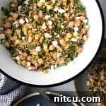 Large white bowl filled with bulgur wheat, veggies, and feta salad.