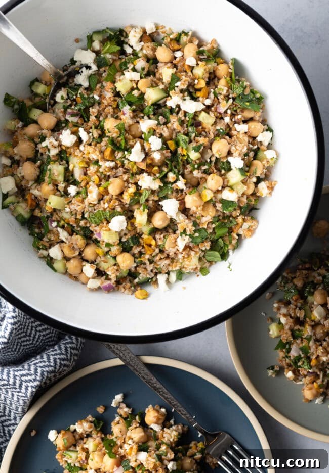 Large white bowl filled with bulgur wheat, veggies, and feta salad.