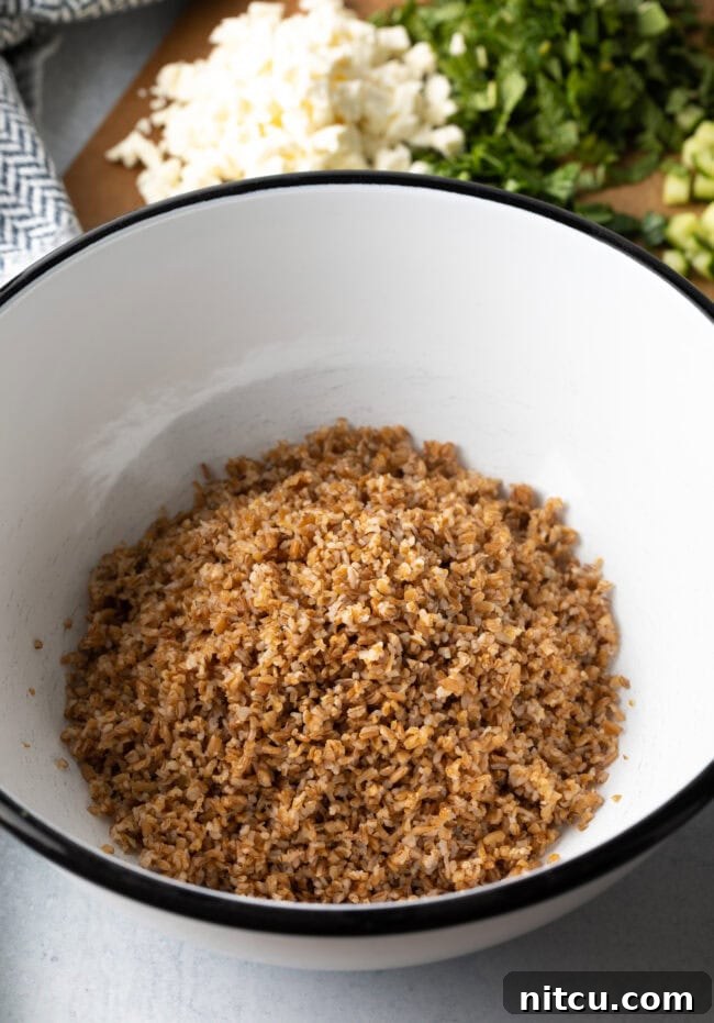 Large white salad bowl with cooked bulgur wheat.