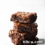 Stack of 4 brownies on a white background.