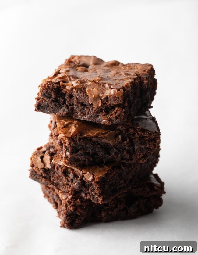 Stack of 4 brownies on a white background.