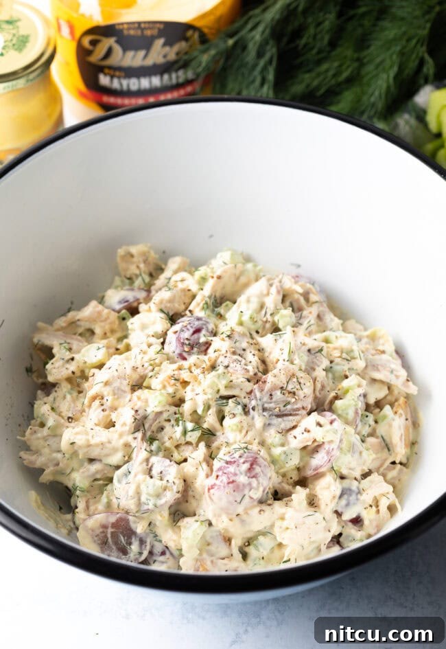 All ingredients for leftover turkey salad combined in white bowl.