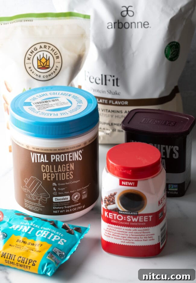 Recipe ingredients in their packages: Almond flour, erythritol sweetener, unsweetened cocoa powder, collagen peptides, and sugar-free chocolate chips, laid out neatly.