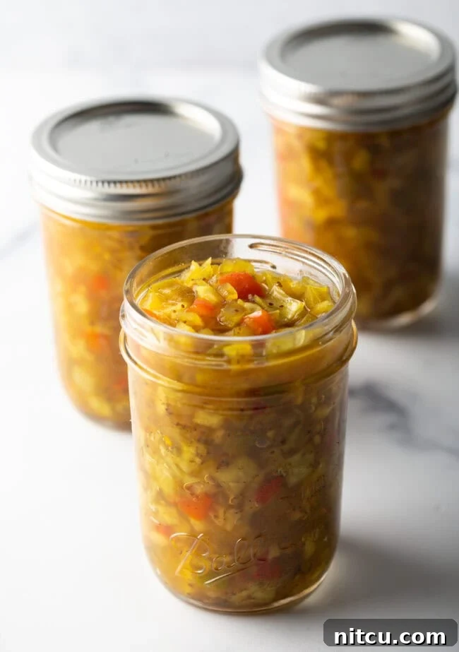 3 glass jars of southern chow chow relish. Front jar has lid off, back two jars have metal lids on.