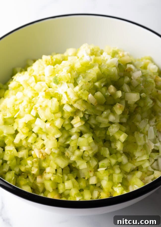 Adding chopped tomatillos to the bowl.