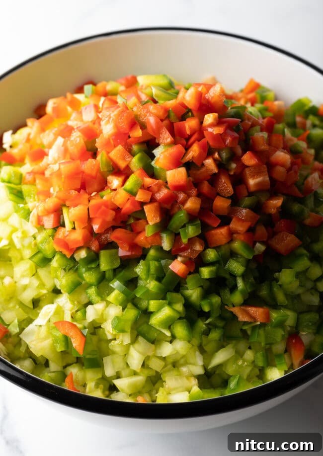 Adding chopped bell pepper to the bowl of veggies.