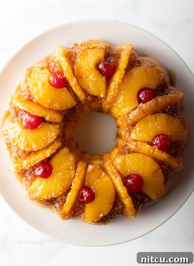 Top-down perspective of the pineapple upside down Bundt cake adorned with bright red cherries, highlighting its exquisite presentation.