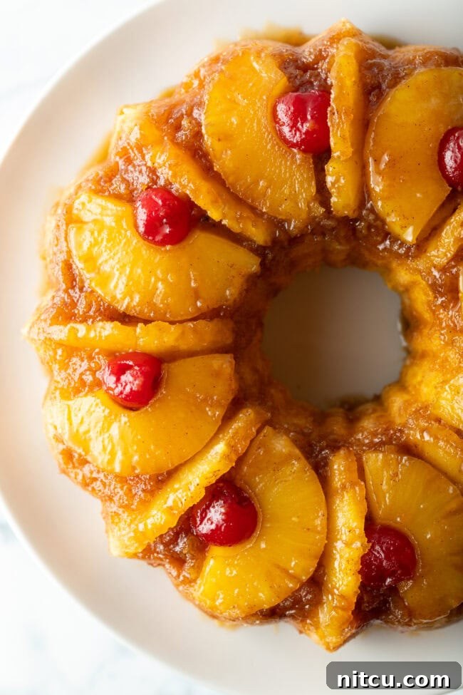 Top-down view of the perfectly baked pineapple upside down Bundt cake, showcasing its ring shape and attractive cherry and pineapple topping.