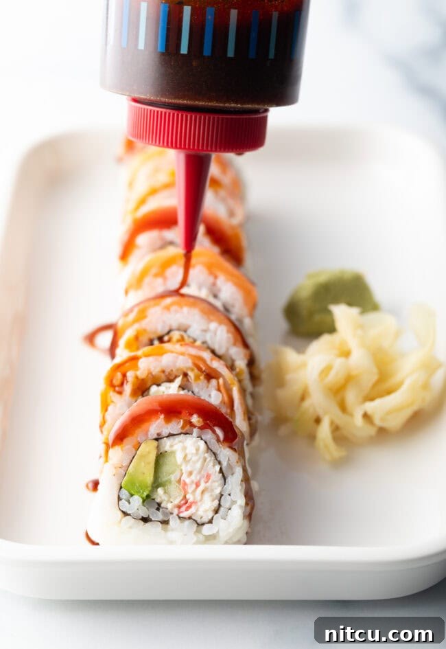 Sushi roll on a white rectangle plate. A squirt bottle is drizzling eel sauce made with 3 ingredients across the top of the roll.