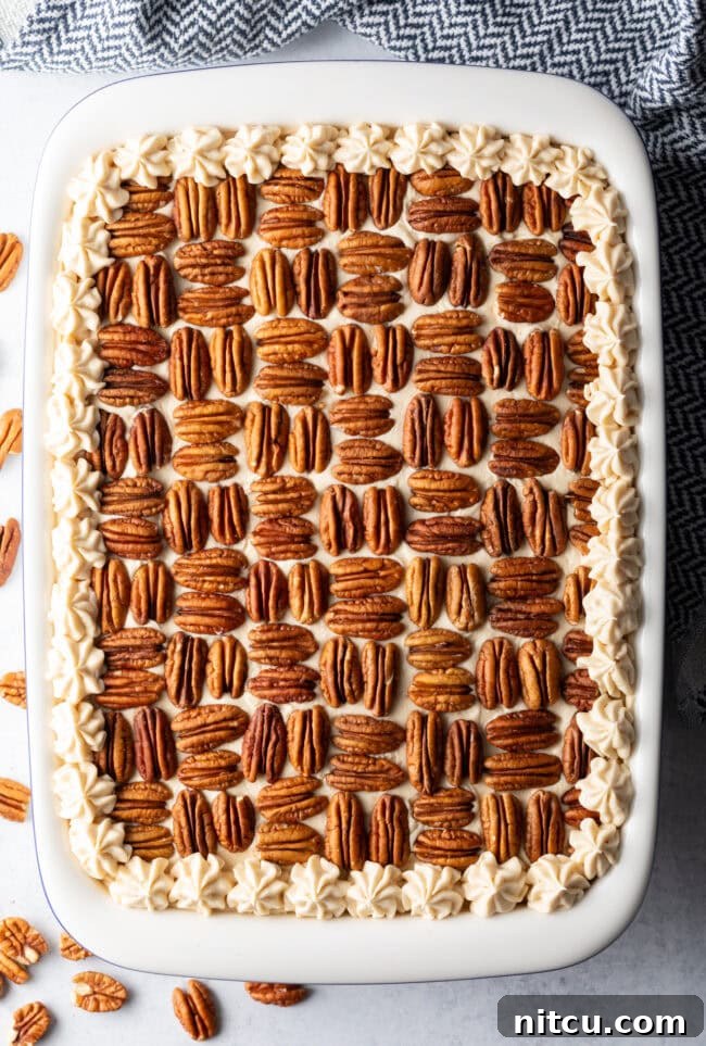 Rectangle butter pecan cake, topped with nut halves and piped with frosting around the edge.