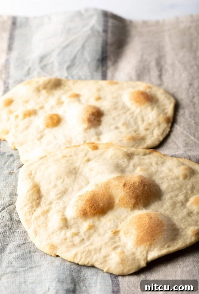 Two pieces of unleavened bread laying on a gray background, ready to be served.