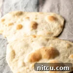 Two pieces of unleavened bread laying on a gray background.