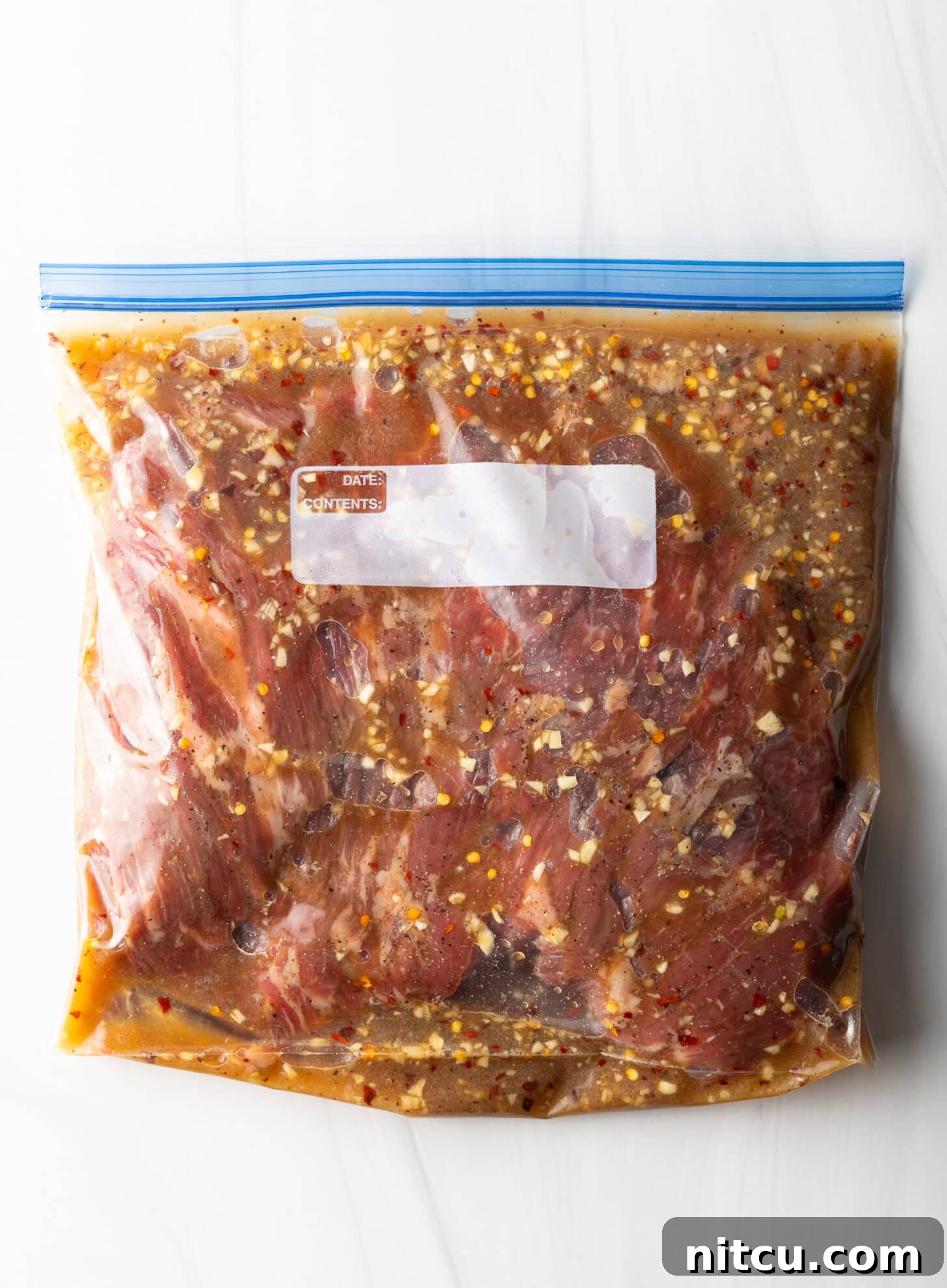 Raw meat in a ziploc bag with marinade.