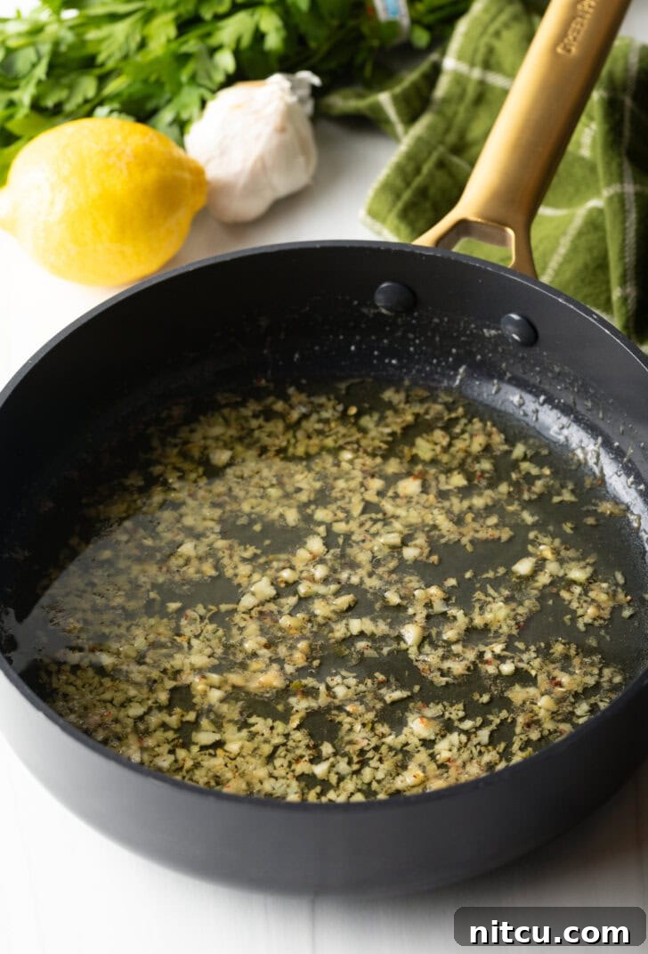 Butter and minced garlic in a black skillet.