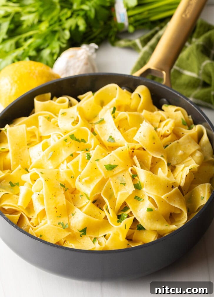 Black skillet with cooked garlic butter noodles.