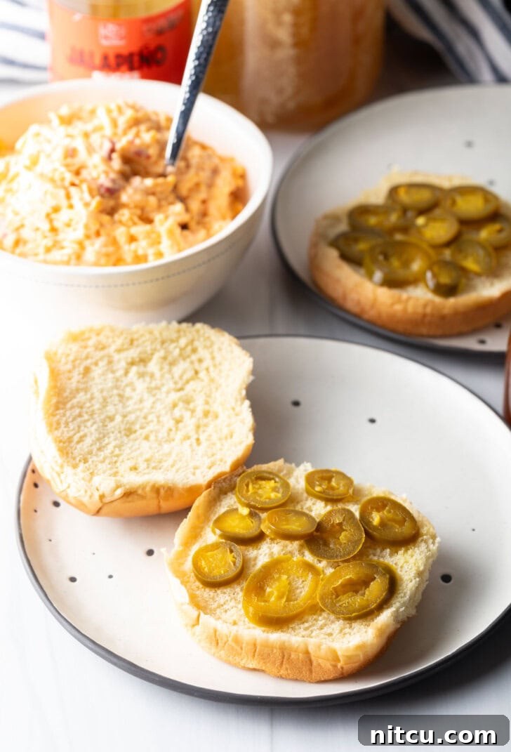 9 slices of pickled jalapenos on the bottom half of a burger bun.