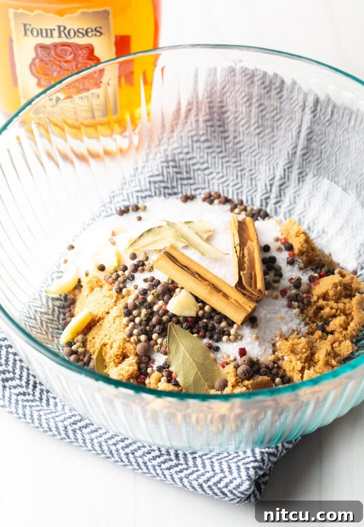 Glass bowl containing a well-proportioned mixture of dry brine spices, coarse kosher salt, and packed brown sugar, perfectly poised for liquid addition.