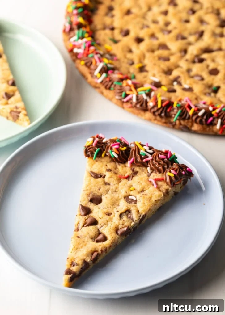 One triangle slice of homemade cookie cake on a pastel blue plate.