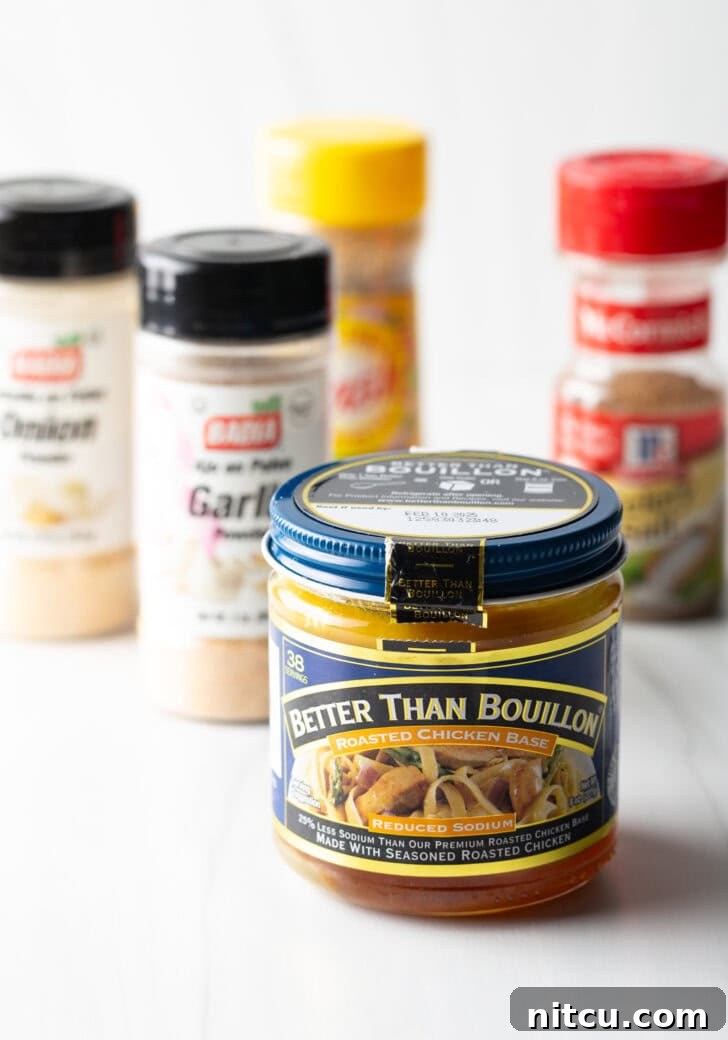 Collection of essential ingredients in jars: Chicken bouillon, garlic powder, a dried herb blend (like Mrs. Dash), onion powder, and celery salt.