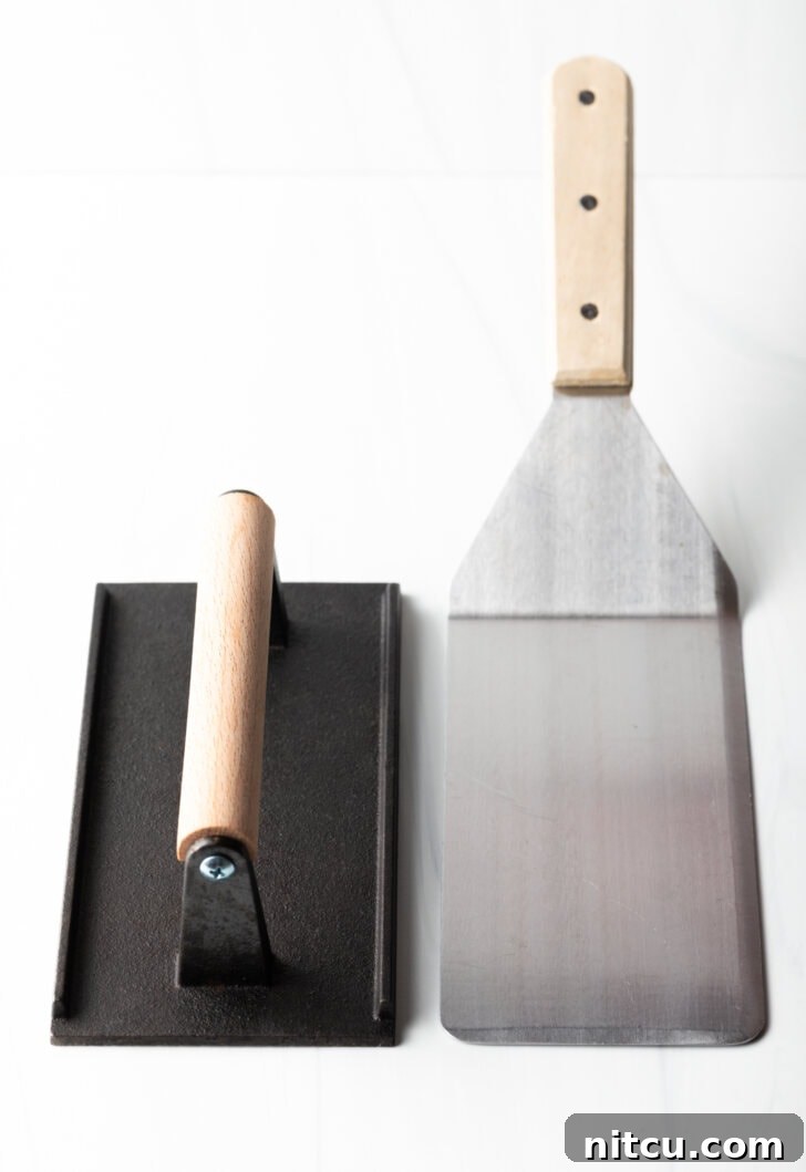 Side by side a flat press and a flat metal spatula.