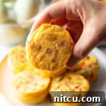 Hand holding an egg bite to camera.