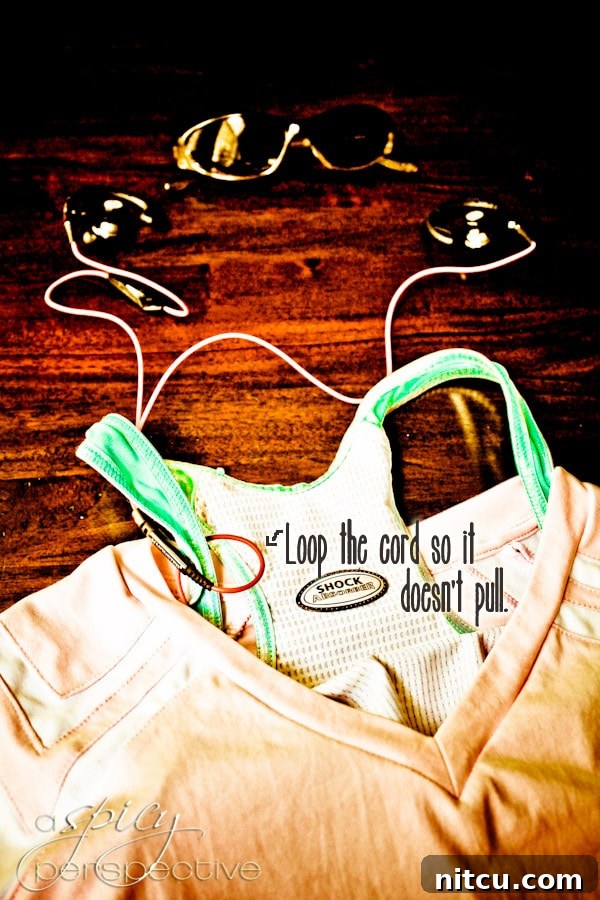 A detailed shot showing how to loop a headphone cord around a sports bra for security during a run.