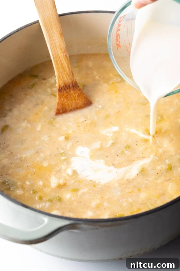 Adding cream to the soup base.