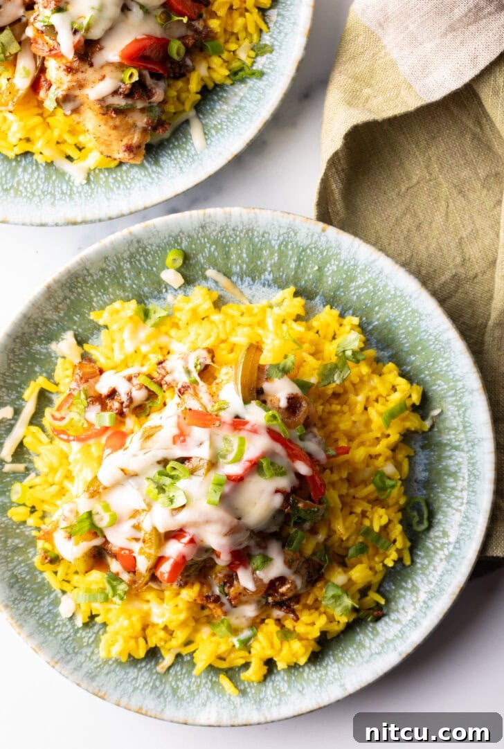 A vibrant serving of Chori Pollo (chicken chorizo) topped with melted cheese and fresh herbs, presented on a bed of fluffy yellow rice, capturing the essence of Mexican cuisine.