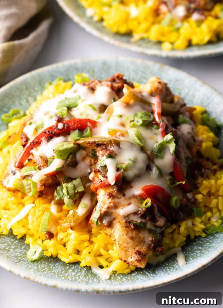 A tantalizing overhead shot of Chori Pollo (chicken chorizo) lavishly covered in melted cheese, resting on a bed of fluffy yellow rice, ready to be enjoyed.