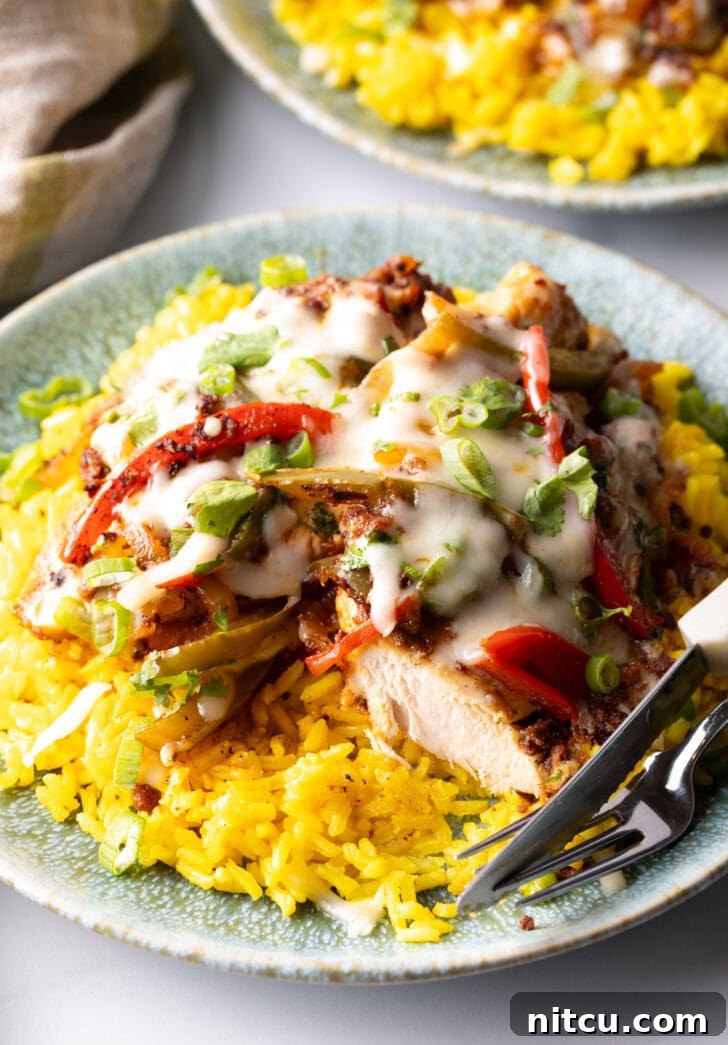 A pan of Chori Pollo with tender chicken, spicy chorizo, and colorful peppers smothered in gooey cheese and garnished with fresh cilantro.