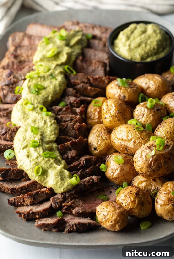 London Broil Marinade - London broil sliced into thick strips, covered with rich green sauce and chopped scallions with baby potatoes on the side.