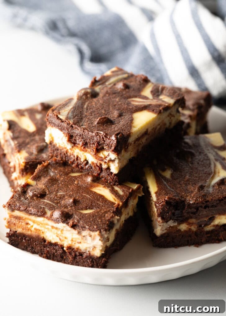 A plate featuring five delicious cheesecake brownies, with one stacked invitingly on top of another.