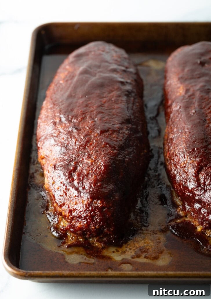 A top-down view showcasing two perfectly smoked meatloaves fresh out of the smoker, glistening with a savory glaze.