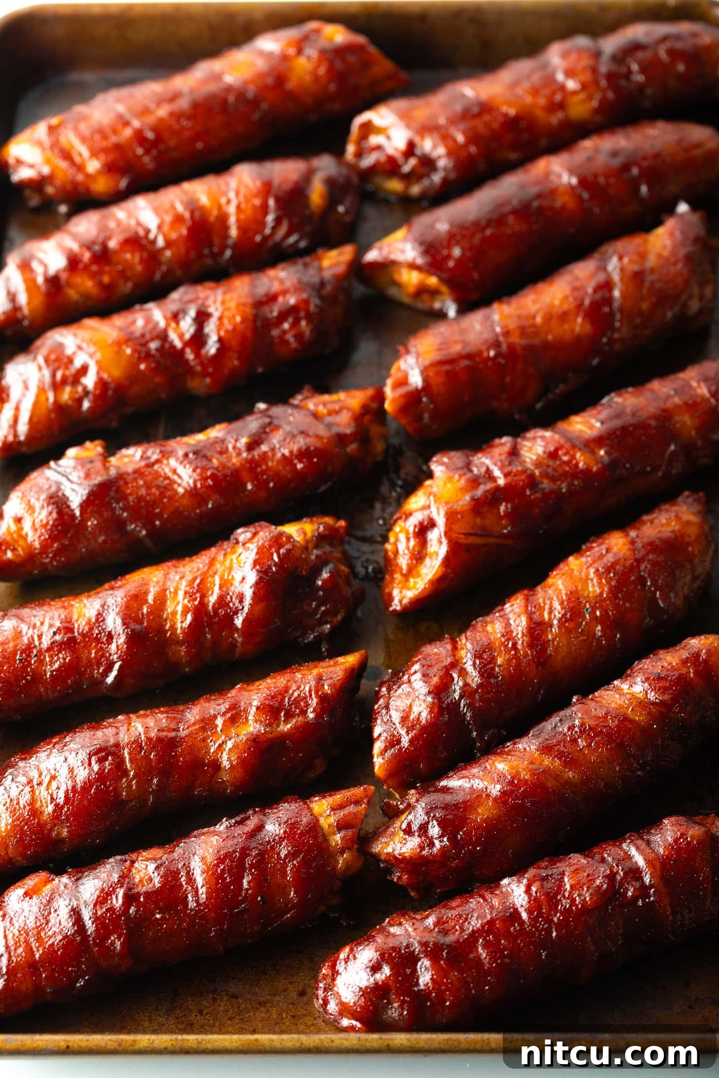 14 bacon wrapped smoked shells on a baking pan.