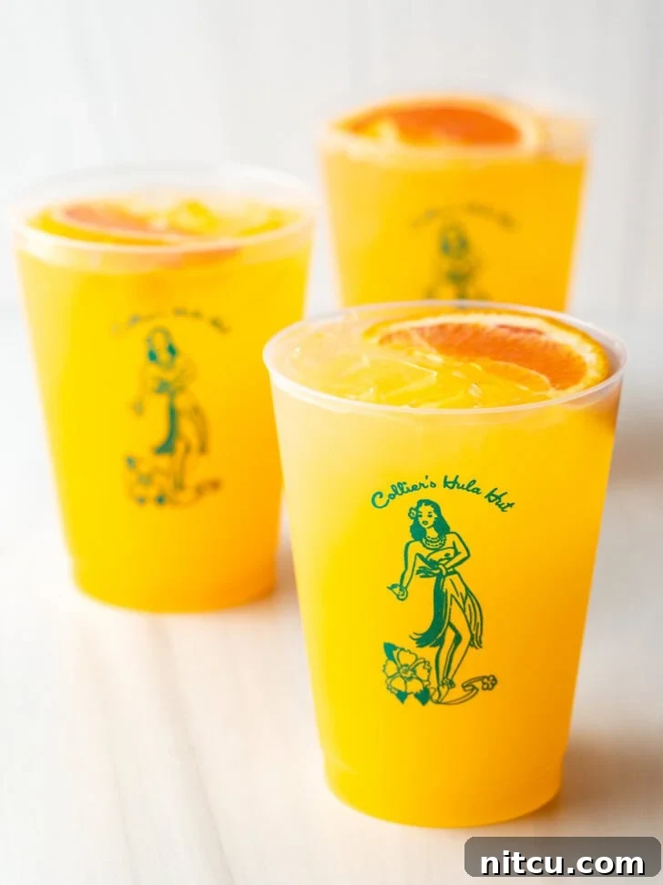 Three Sunny D Vodka Seltzer drinks, each in a glass cup with a slice of orange on top.
