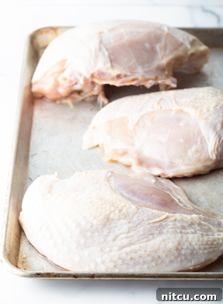 3 turkey breasts on a baking sheet.