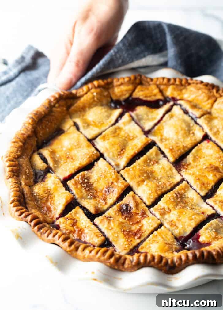A vibrant cherry pie with a beautifully baked golden crust, just out of the oven, radiating warmth and delicious aroma.