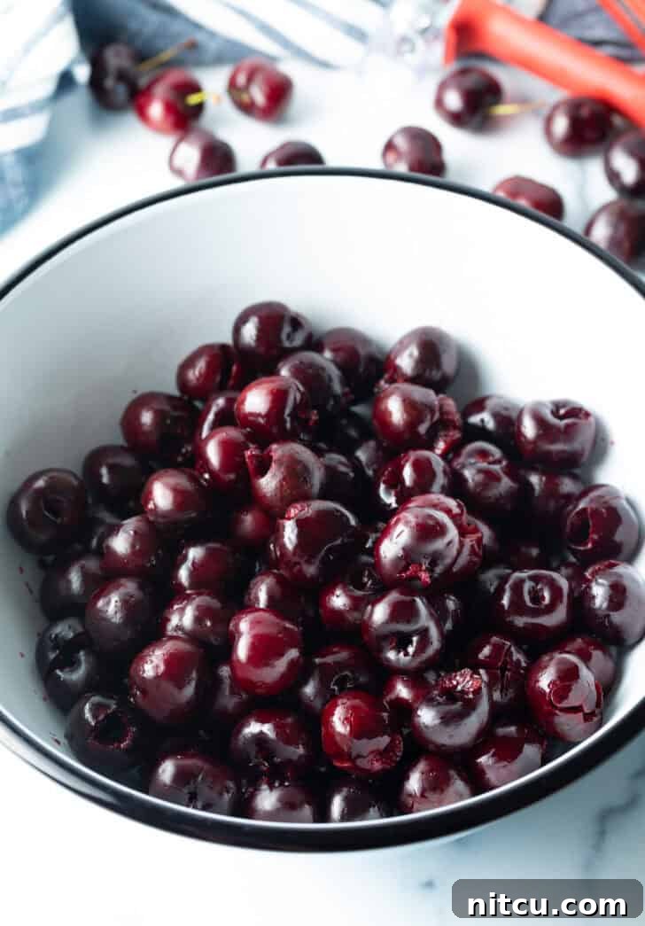 A bowl brimming with glistening fresh red cherries, ready to be transformed into a delicious pie filling, symbolizing the start of a delightful baking project.