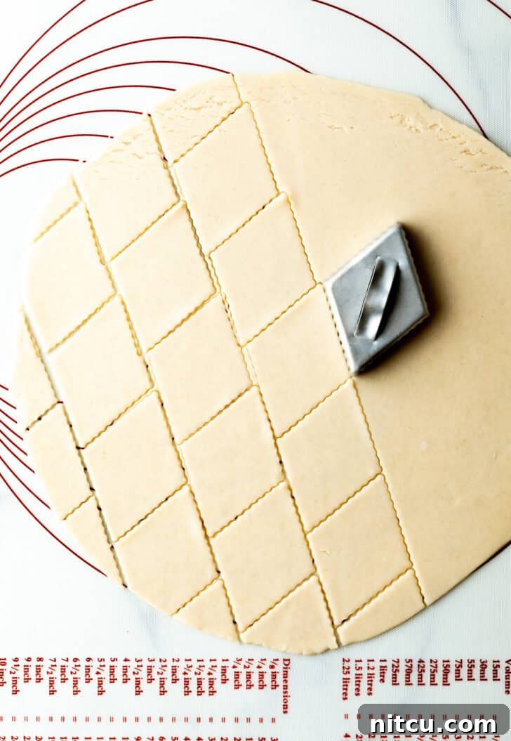 A diamond stamper creates an elegant pattern on raw pie dough, showcasing a decorative technique for the pie's top crust.