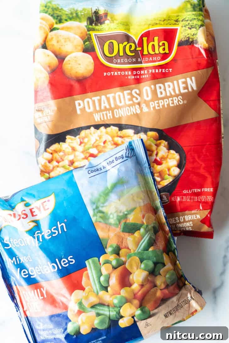 A bag of frozen potatoes o'brien and a bag of frozen mixed vegetables.