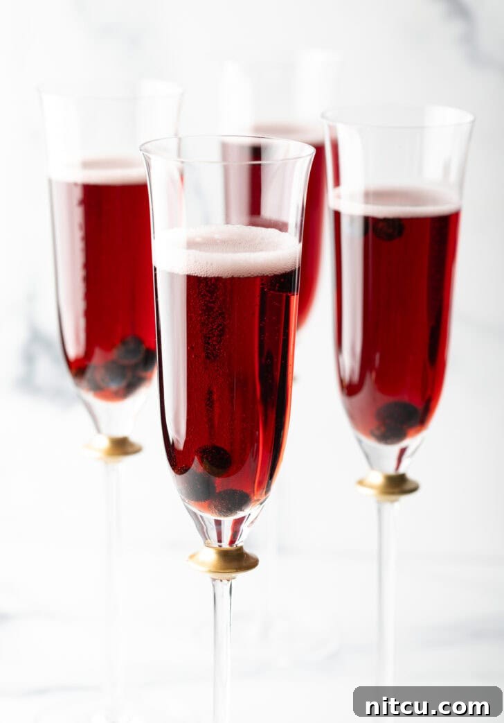 A festive spread featuring four Kir Royale cocktails alongside an assortment of appetizers, perfect for a gathering.