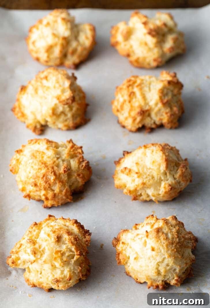 Two rows of 8 baked drop biscuits on a baking sheet.