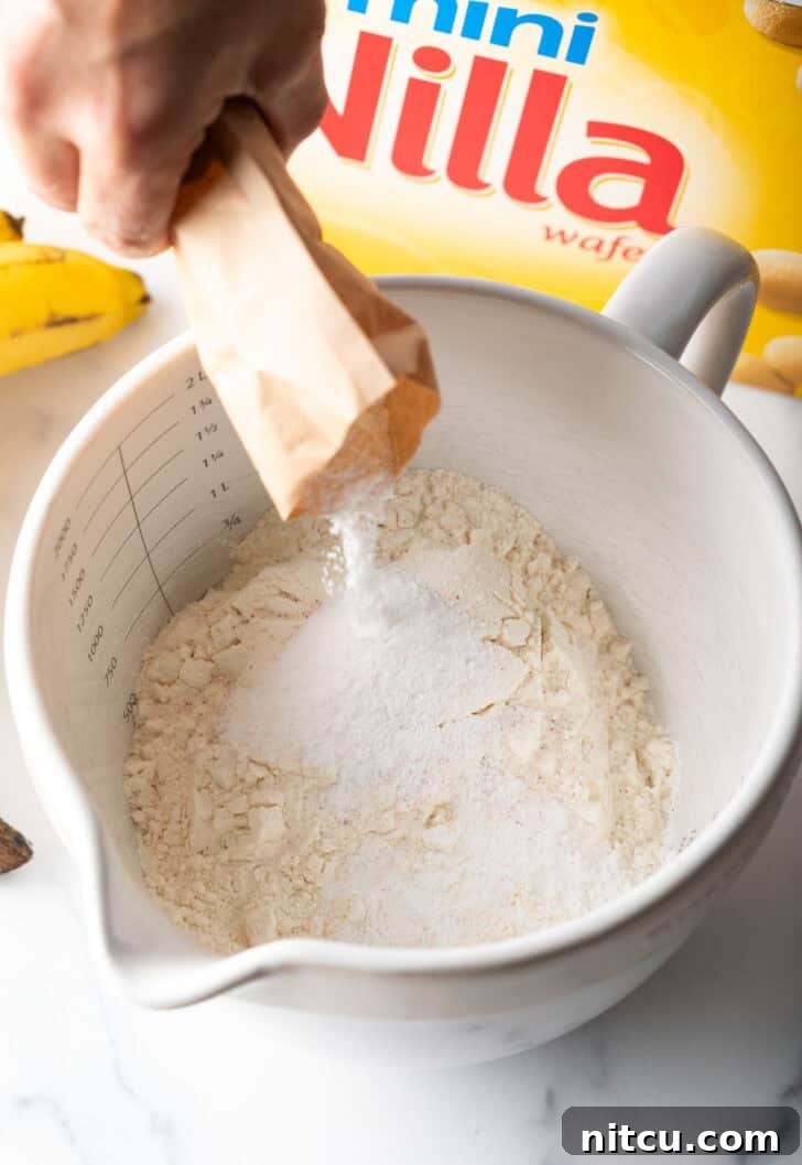 Butter and sugar being creamed in a stand mixer.