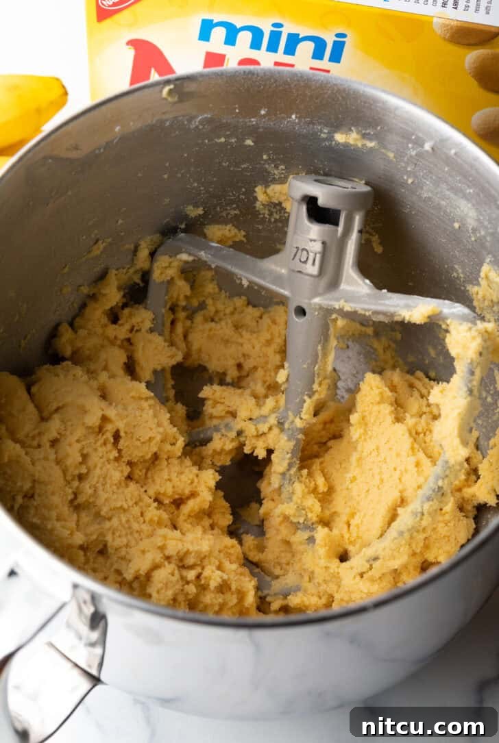 Eggs and vanilla being added to the creamed butter and sugar mixture.