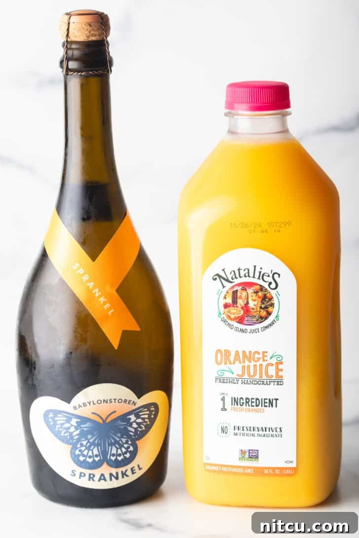 A bottle of champagne next to a bottle of orange juice.